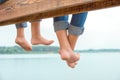 Two brothers swung their legs from the wooden pier .Family vacation on the lake.