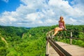 Woman sit at balcony on high cliff with jungle view Royalty Free Stock Photo