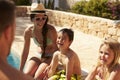 Family On Vacation Relaxing By Outdoor Pool Royalty Free Stock Photo