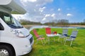 Family vacation, RV camper travel concept, motorhome, table and chairs in campsite, kids on background Royalty Free Stock Photo