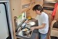 Family vacation, RV holiday trip, travel and camping, man cooking in camper interior Royalty Free Stock Photo