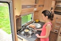 Family vacation, RV holiday trip, travel and camping, woman cooking in camper, motorhome interior Royalty Free Stock Photo