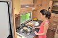 Family vacation, RV holiday trip, travel and camping, woman cooking in camper, motorhome interior Royalty Free Stock Photo