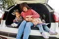 Family at vehicle interior. Mother with her daughters. Children in trunk. Traveling by car in the mountains, atmosphere concept