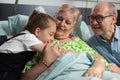 Family visiting sick retired senior woman in hospital ward Royalty Free Stock Photo