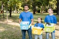 Family of volunteers holding containers with