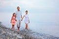 Family walk on beach in evening, focus on mother Royalty Free Stock Photo