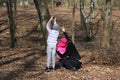 Family for a walk. Dad shows daughter on squirrel, which sits on tree. Girl takes pictures of the squirrel on the phone.
