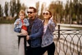 Family walk, father and mother hold their daughter in their arms, the family walks along the embankment of the river, sunset, mom Royalty Free Stock Photo