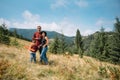 Family walk on the field near the mountains in sunny day yellow grass father mother son holding hands on the sunset Royalty Free Stock Photo