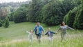 Family on walk in forest, going through meadow. Picking mushrooms, herbs, flowers picking in basket, foraging. Concept