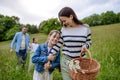 Family on walk in forest, going through meadow. Picking mushrooms, herbs, flowers picking in basket, foraging. Concept