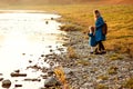 Family on a walk near river coast. Autumn vacation, travel, lifestyle. Mother and daughter having fun together Royalty Free Stock Photo