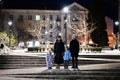 Family walk through the night city in the winter. A woman and three children in evening Royalty Free Stock Photo