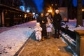 Family walk through the night city in the winter. A woman and three children in evening drink hot drink in cups Royalty Free Stock Photo