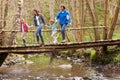 Family Walking Across Wooden Bridge Over Stream In Forest Royalty Free Stock Photo