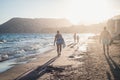 Family walking along the ocean in the sunset Royalty Free Stock Photo