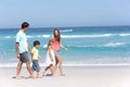 Family Walking Along Sandy Beach Royalty Free Stock Photo
