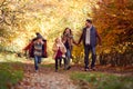 Family Walking Along Track In Autumn Countryside With Children Running Ahead Royalty Free Stock Photo