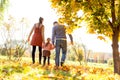 Family walking in autumn park at sunset Royalty Free Stock Photo