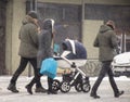 Family walking with the child in the stroller in snowy winter day. Intentional motion blur Royalty Free Stock Photo