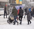 Family walking with the child in the stroller in snowy winter day. Intentional motion blur Royalty Free Stock Photo