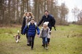 Family walking dog together in the countryside, front view Royalty Free Stock Photo