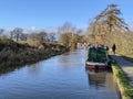 A family walking down the canal footpath by the narrowboats