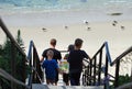 Family walking down stairs to beach in Laguna Beach, California.