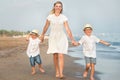 Family walking on the evening beach during sunset.Mother and two sons. Royalty Free Stock Photo