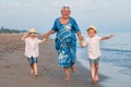 Family walking on the evening beach during sunset.Grandmother and two grandsons.