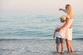 Family walking on the evening beach during sunset.Mother and son enjoy views of the sea. Royalty Free Stock Photo