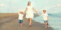 Family walking on the evening beach during sunset. Royalty Free Stock Photo