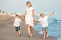 Family walking on the evening beach during sunset.Mother and two sons. Royalty Free Stock Photo