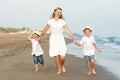 Family walking on the evening beach during sunset.Mother and two sons. Royalty Free Stock Photo