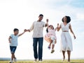 Family, walking and holding hands outdoor at a park with love, care and happiness together in nature. Young man and