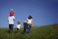 Family walking in meadow, view from behind. Royalty Free Stock Photo