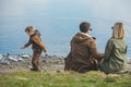 family walking near water. sitting at the beach. little kid throwing rock in water Royalty Free Stock Photo