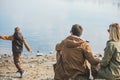 family walking near water. sitting at the beach. little kid throwing rock in water Royalty Free Stock Photo