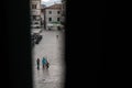 A family in the Old Town of Kotor, Montenegro, shot through half-open window shutters