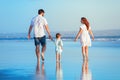 Family walking by sunset beach