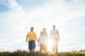 Family walking in sunset over a summer meadow Royalty Free Stock Photo