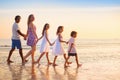 Family walking on tropical beach at sunset Royalty Free Stock Photo