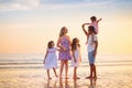 Family walking on tropical beach at sunset Royalty Free Stock Photo