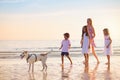 Family walking on tropical beach at sunset Royalty Free Stock Photo