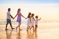 Family walking on tropical beach at sunset Royalty Free Stock Photo