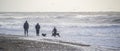 Family walking and watching the crashing waves on the Cornish coast Royalty Free Stock Photo