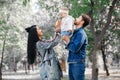 The family walks in the park, the father holds the little daughter over his head, the mother laughs and claps, the family enjoys Royalty Free Stock Photo