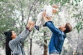 The family walks in the park, the father holds the little daughter over his head, the mother laughs and claps, the family enjoys Royalty Free Stock Photo