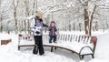 Family walks during snowfall in Moscow, Russia. Baby girl with mother are in winter park Royalty Free Stock Photo